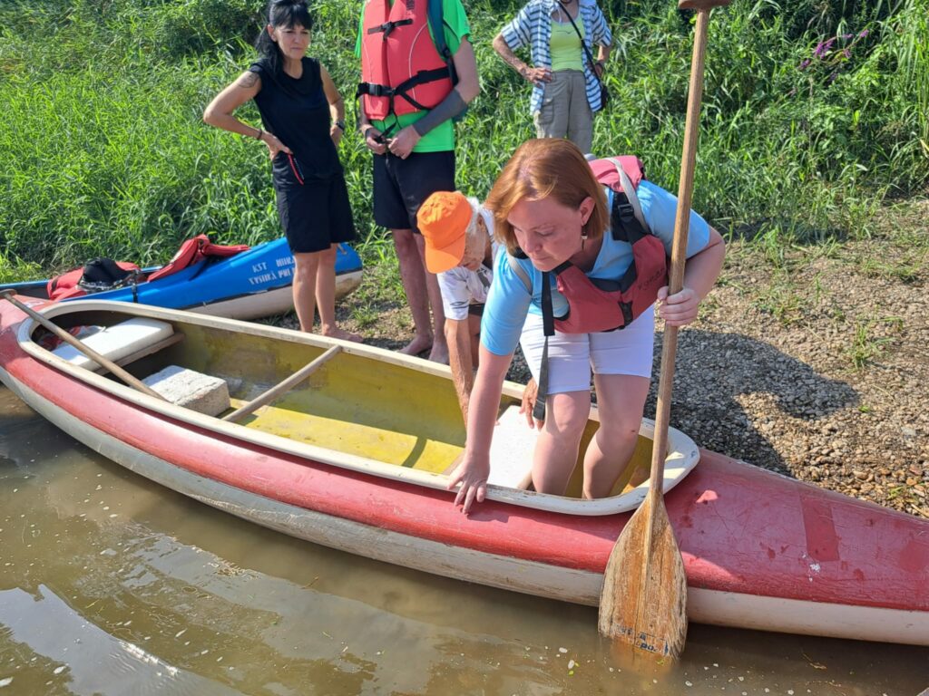 Na fotografii účastníčka splavu nasadá do loďky.