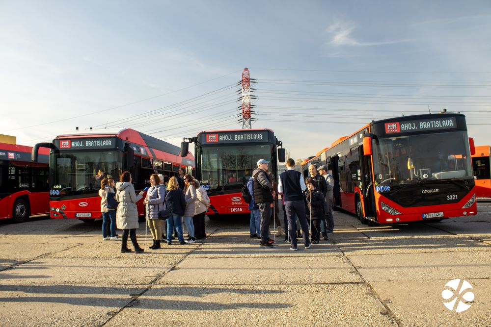 Na obrázku sú tri autobusy s označením "Ahoj, Bratislava" a pred nimi dva hlúčiky ľudí, pracovníci DPB i ľudia s bielou palicou či bez nej