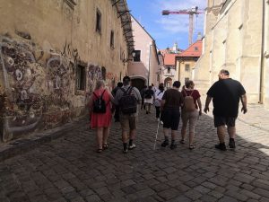 Pešo kráčajúci ľudia ulicou Starého mesta.  